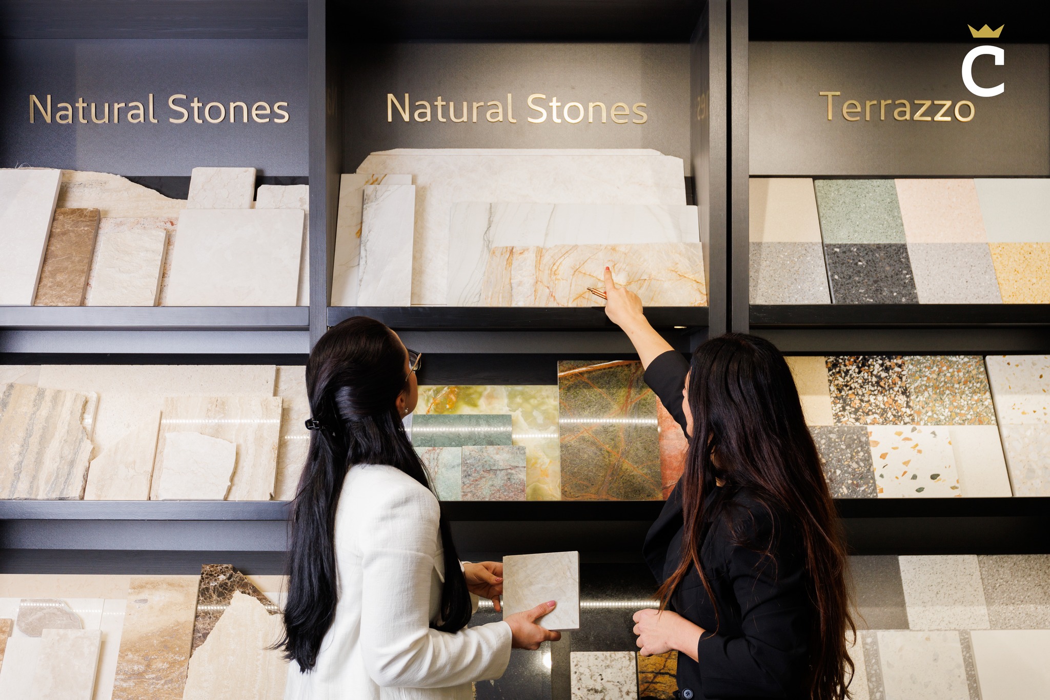 Two people reviewing natural stone and terrazzo material samples in the Cordina showroom.